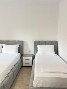 two beds sitting next to each other in a room at Mme apartment in Kamëz