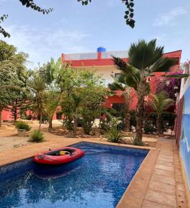 a red boat in a swimming pool next to a building at Paradise in Yène