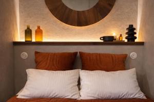 a bed with two pillows and a shelf above it at Résidence Nakiya in Sainte-Marie