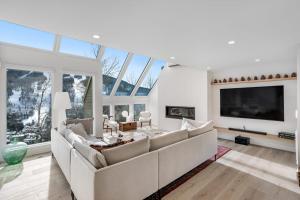 a living room with a large couch and a tv at Snowfall Sanctuary, Unit 12 in Vail