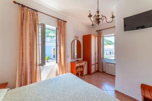 a bedroom with a bed and a desk and windows at Hotel Monti in Casamicciola Terme