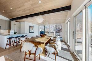 a kitchen and dining room with a wooden table and chairs at Snowfall Sanctuary, Unit 12 in Vail