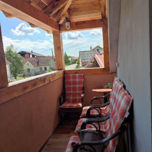a balcony with two chairs and a table and a window at Međimurski San in Lopatinec