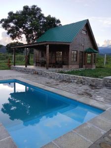 a log cabin with a pool in front of it at Cabañas amanecer alegre in Salta