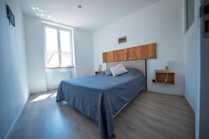 a bedroom with a blue bed and a window at La Tomette - Gîte Eco Responsable - Le charme de l'authentique Climatisé in Maury