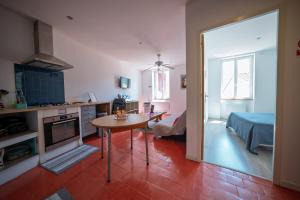 a kitchen and living room with a table in a room at La Tomette - Gîte Eco Responsable - Le charme de l'authentique Climatisé in Maury