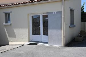 a white door with a glass window on a building at Studio proche océan pour Deux personnes in Longeville-sur-Mer