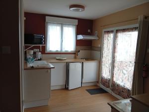 a small kitchen with a sink and a refrigerator at Studio proche océan pour Deux personnes in Longeville-sur-Mer +2 photos