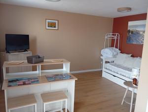a room with a bed and a desk with a tv at Studio proche océan pour Deux personnes in Longeville-sur-Mer