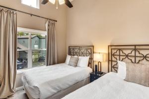 two beds in a bedroom with a window at Aspen Getaway in Edwards