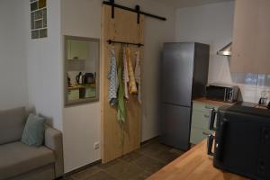 a kitchen with a refrigerator and a couch in a room at Am Burg in Klotten