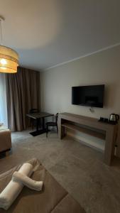 a living room with a couch and a tv on the wall at Apartamenty Nadjeziorna in Ełk