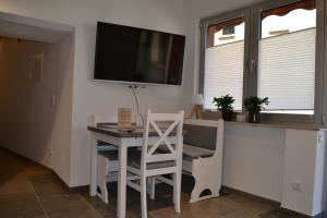 a room with a table and a television on a wall at Am Burg in Klotten