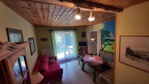a living room with a red couch and a table at Appartementhaus Schwarzwaldblick in Lauterbach