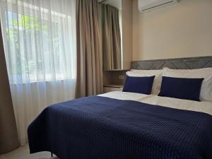 a bedroom with a blue and white bed with a window at Nautico apartment with swimming pool in Opatija +57 photos