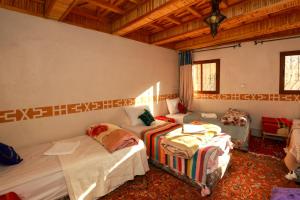 a room with two beds and a couch in it at Eagle Lodge in Imlil