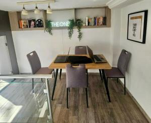 a dining room table with a laptop and chairs at one hostel in Tabarka