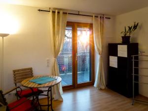 um quarto com uma mesa e uma porta de vidro com uma janela em Appartement an der Seefelder Mühle em Seefeld