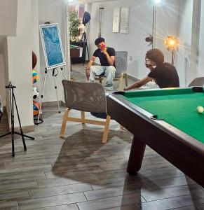 a group of men sitting around a pool table at one hostel in Tabarka