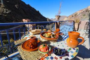 a table with plates of food on a balcony at Eagle Lodge in Imlil