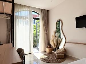 a bedroom with a bed and a mirror and a table at Olivea Boutique Hotel Phu Quoc in Phú Quốc