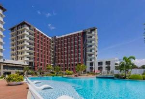 a large swimming pool in front of a large building at Althea's Horizon Stay - Primeworld District in Pajak