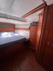 a small room with a bed and a wooden cabinet at BeliBoat in Cascais