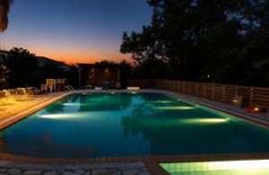 a swimming pool with a sunset in the background at 2BR Apt Balconies Pool 3 in Gouvia +34 photos