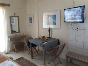 a dining room with a table and a television on the wall at 2BR Apt Balconies Pool 3 in Gouvia