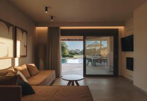 a living room with a couch and a table at Ora Blu Villas in Mytikas
