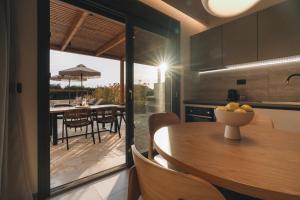 a kitchen and dining room with a table and chairs at Ora Blu Villas in Mytikas