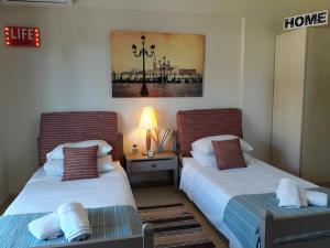 a room with two beds and a table with a lamp at 2BR Gouvia – Apt 6 in Gouvia +31 photos