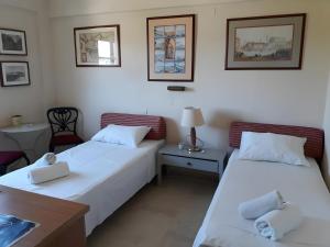 two beds in a room with a table and a desk at Cozy 2BR Corfu – Apt 9 in Gouvia +31 photos