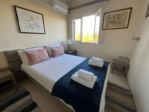 a bedroom with a large bed with two towels on it at Cozy 2BR Corfu – Apt 9 in Gouvia