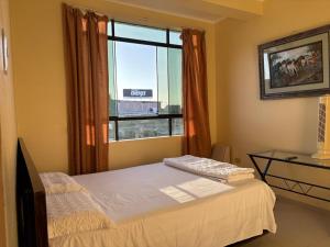 a bedroom with a bed and a large window at Hotel Graxiomy in Sechura