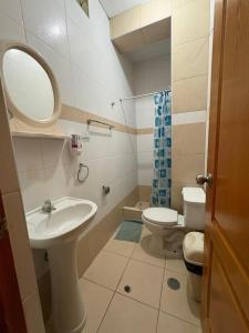 a bathroom with a sink and a toilet and a mirror at Hotel Graxiomy in Sechura