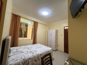 a small bedroom with a bed and a window at Hotel Graxiomy in Sechura