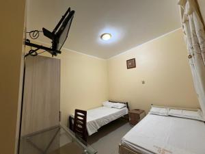 a room with two beds and a glass table at Hotel Graxiomy in Sechura