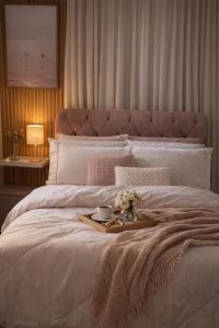 a bed with a tray of flowers and a plate of food at Spazio Dela vita in Sorocaba