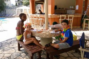 a group of children sitting at a table at 2BR Family Gouvia – Apt 2 in Gouvia