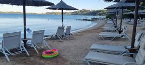 a group of chairs and umbrellas on a beach at Value Stay for 4 – Apt 11 in Gouvia +35 photos