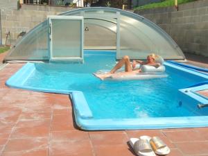 a woman laying on a raft in a swimming pool at Penzion Bedrč in Benešov