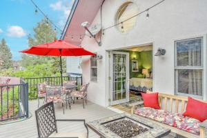 a patio with a table and a red umbrella at Steamboat Villa in Steamboat Springs