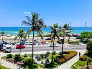 a view of a parking lot with palm trees and the ocean at Apartamento completo Premium-Frente ao Mar Wi-Fi rápido-ar-condicionado in Rio de Janeiro
