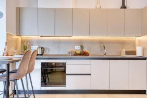 a kitchen with white cabinets and a table and chairs at Floras House in Paradeísion