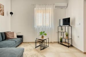 a living room with a couch and a tv at Floras House in Paradeísion