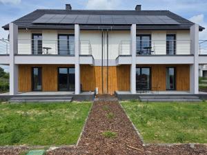 a white house with a black roof at Apartamenty Stargardt in Stargard