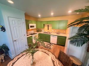 a kitchen with green cabinets and a potted plant at Historic Ziegler Inn and Suites with Whimsical Themed Rooms in New Bern