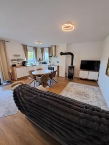 a living room with a couch and a table and a kitchen at Ferienwohnung Hahnenblick in Hahnenbach