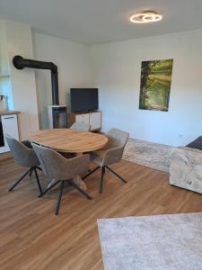 a living room with a wooden table and chairs at Ferienwohnung Hahnenblick in Hahnenbach